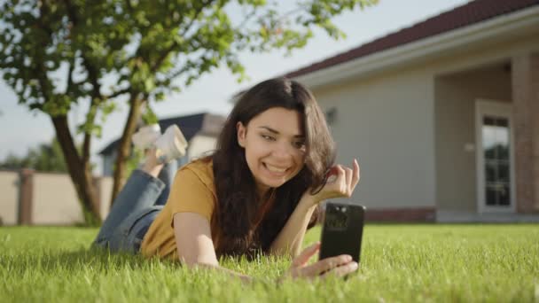 Söt Ung Brunett Kommunicerar Videosamtal Telefon Liggande Grön Gräsmatta Lycklig — Stockvideo