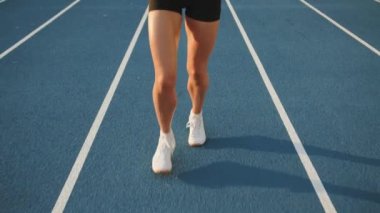 Stadyumun açıklarındaki atletizm pistinde koşan narin kadın bacakları. Dar şortlu, terli seksi bacaklar, beyaz çoraplar, snickers. Parça bölümleri. Yüksek kalite 4k görüntü