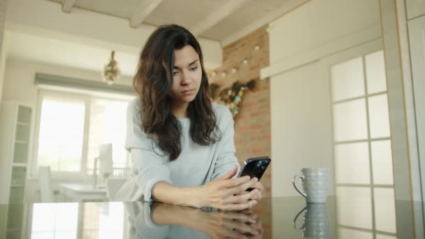 Разочарованные Симпатичные Брюнетки Печатают Мобильном Телефоне Сидя Столом Просторной Светлой — стоковое видео