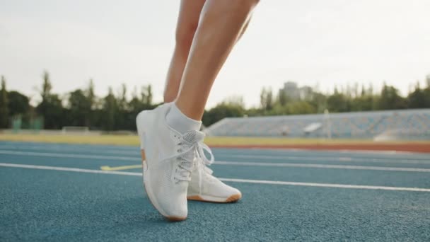 白い靴下のスレンダー女性の足 外で足首円を実行スニーカー 新鮮な空気の中でスタジアムで実行するための準備 トライブス 高品質4K映像 — ストック動画
