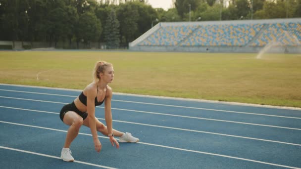 Urheilullinen Blondi Suorittaa Jalat Venyttely Stadionilla Lämmittelyä Juoksua Nuori Nainen — kuvapankkivideo