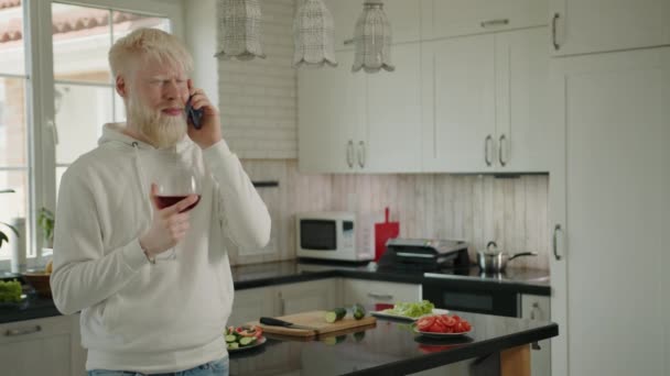 Homem Albino Alegre Segurando Copo Vinho Tinto Falando Celular Cozinha — Vídeo de Stock