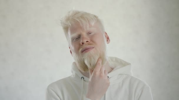 Mittlere Nahaufnahme Eines Nachdenklichen Albino Mannes Der Vor Weißem Hintergrund — Stockvideo