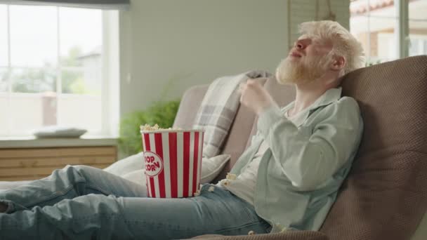 Homme Albinos Joyeux Assis Dans Grand Salon Moderne Sur Canapé — Video