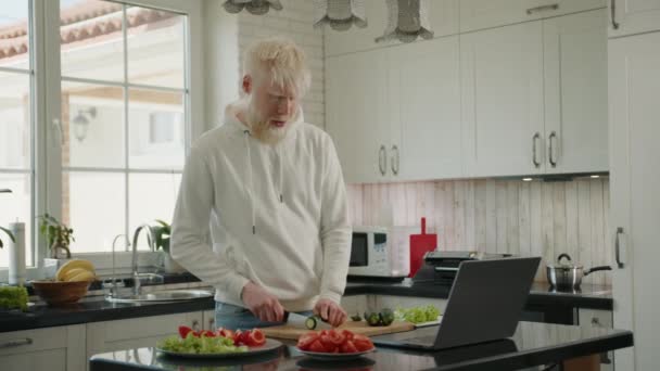 Pria Albino Tampan Memotong Mentimun Pada Papan Potong Meja Dapur — Stok Video