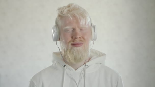 Beyaz Kapüşonlu Beyaz Kulaklıklı Beyaz Arka Planda Sevdiği Şarkıyla Dans — Stok video