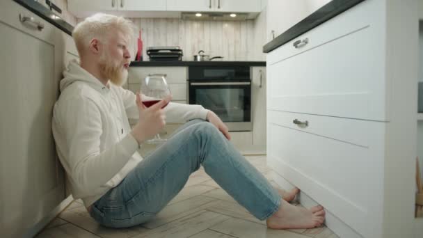 Hafif Sarhoş Genç Albino Adam Mutfakta Yerde Oturmuş Kırmızı Şarap — Stok video
