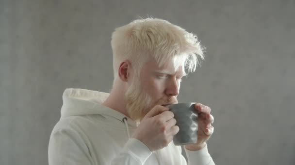 Młody Brodaty Mężczyzna Albinizmem Pijący Gorącą Herbatę Zamykający Oczy Przyjemnością — Wideo stockowe