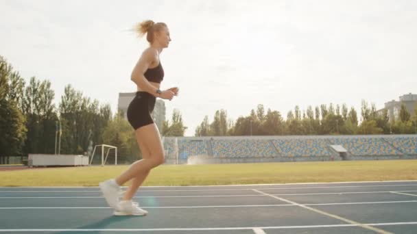 Schlanke Junge Blondine Läuft Einem Sonnigen Tag Auf Der Leichtathletik — Stockvideo