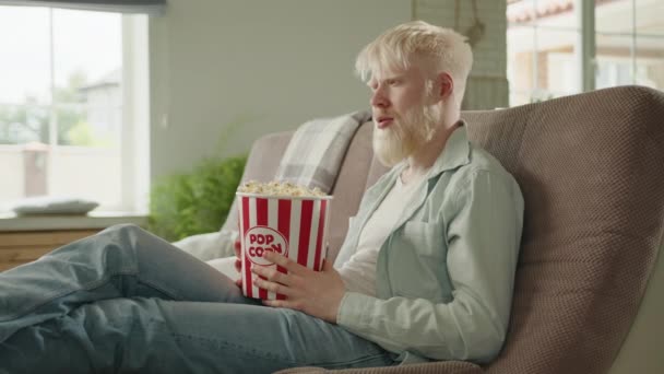 Homem Albino Assistindo Filme Assustador Sentado Sofá Grande Sala Segurando — Vídeo de Stock