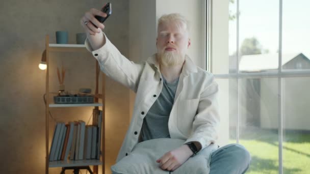 Jovem Albino Fazendo Selfie Usando Smartphone Quarto Aconchegante Sentado Janela — Vídeo de Stock