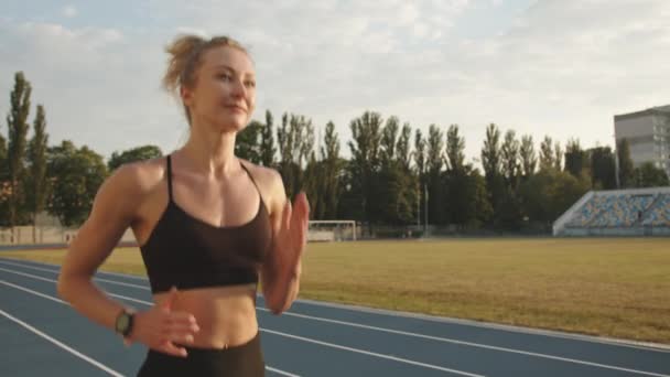 Trening Gang Ung Blondine Med Muskuløs Kropp Løper Atletisk Bane – stockvideo
