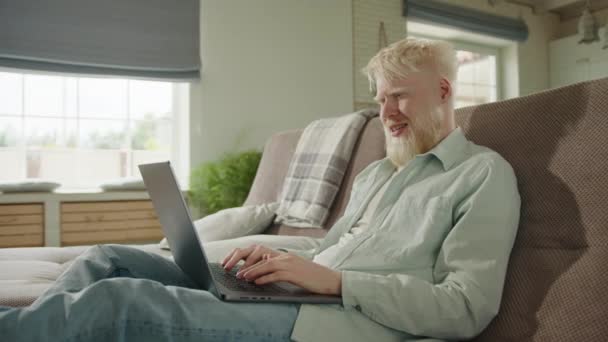 Albino Man Ontspannen Bank Thuis Communiceren Video Link Laptop Albino — Stockvideo