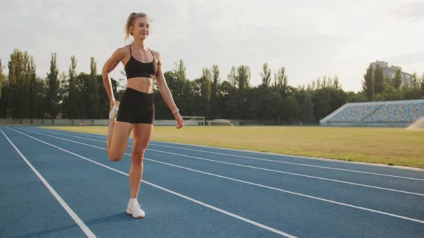 Koşu Pistinde Stadyumda Bacakları Esneten Gülümseyen Sarışın Dörtlü Esneme Güneşli — Stok video