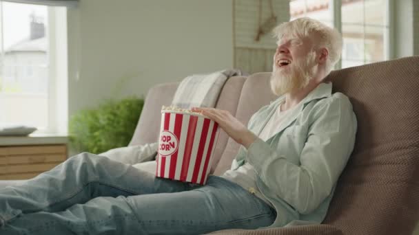 Ridendo Uomo Albino Barbuto Guardando Commedia Seduto Sul Divano Con — Video Stock