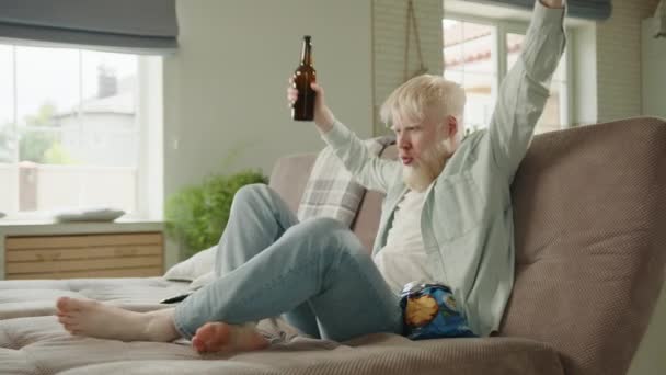 Albino Assistindo Jogo Futebol Bebendo Cerveja Comendo Batatas Fritas Sentado — Vídeo de Stock