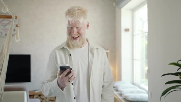 Ευτυχισμένος Άνθρωπος Αλμπίνο Μιλάει Στο Smartphone Στο Σαλόνι Άνθρωπος Δέχεται — Αρχείο Βίντεο
