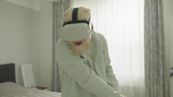 白化病患者戴着虚拟现实眼镜 在大房子里玩射击游戏 用的是大玩具枪 白化病人沉浸在虚拟现实中 感觉像个间谍 高质量的4K镜头 — 图库视频影像