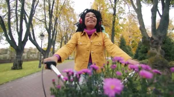Крупный План Темноволосой Кудрявой Афро Американки Наушниках Велосипеде Хризантемами Воздушными — стоковое видео