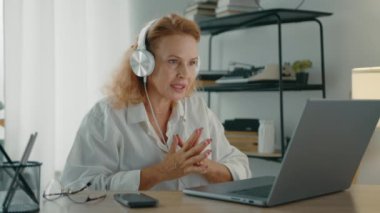Bilgisayarlı, cep telefonlu, video grafiği boyunca özgüvenli ve ihtiyatlı bir şekilde konuşan talimat veren, açıklama yapan olgun bir hanım. Yüksek kalite 4k görüntü