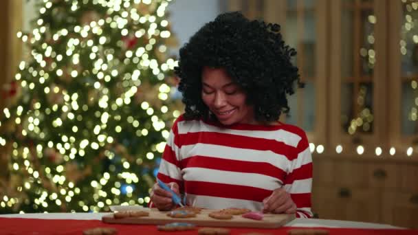 Smiling Pretty African Female Process Decorating Gingerbread Cookies Using Tube — Stock Video
