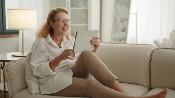 Happy Middle Aged Attractive Woman Sitting Stretched Legs Light Sofa — Stock Video