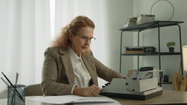 Αρκετά Ώριμη Γυναίκα Γυαλιά Δακτυλογραφεί Γραφομηχανή Κάθεται Στο Γραφείο Στο — Αρχείο Βίντεο