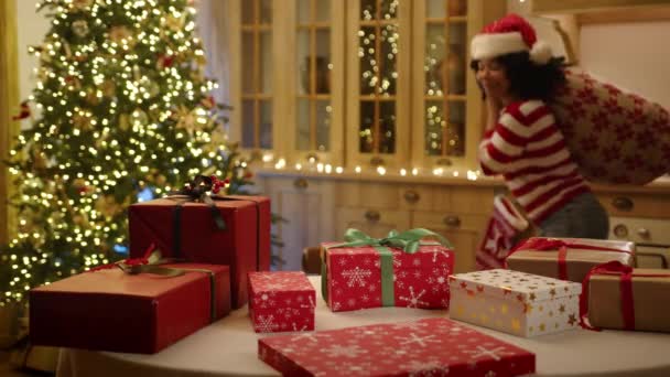 Kędzierzawa Afrykanka Kapeluszu Mikołaja Paluszkach Świątecznie Urządzonej Kuchni Bożonarodzeniowym Workiem — Wideo stockowe