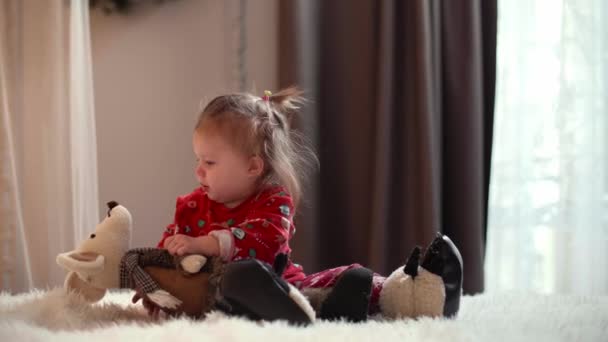 小女孩在白色被褥上玩她的玩具 抱着玩具鼠标的孩子看上去很惊讶 高质量的4K镜头 — 图库视频影像