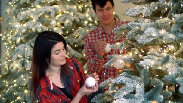 Schönes Paar Schmückt Den Weihnachtsbaum Familie Roten Hemden Hängen Weihnachtskugeln — Stockvideo