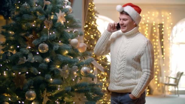 Man Stands Christmas Tree Talks Phone Guy Smiles Laughs Telephone — Stock Video