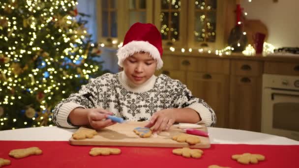 Dítě Smíšené Rasy Malování Tradičních Vánočních Sušenek Kuchyni Zdobené Věnci — Stock video