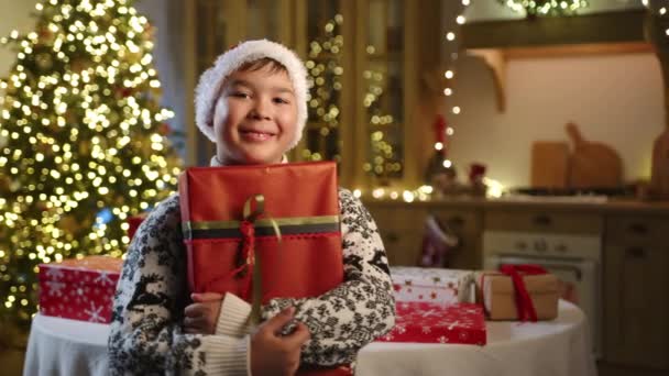 Милий Щасливий Хлопчик Змішаної Раси Прикрашеному Светрі Обіймає Подарункову Коробку — стокове відео