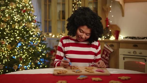 Uśmiechnięta Afroamerykanka Kolorowanki Pierniki Ciasteczka Kuchni Nowoczesnymi Meblami Girlandami Podświetlane — Wideo stockowe