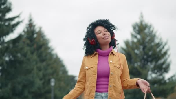 Vrolijke Wandeling Van Lachende Zwarte Dame Luisteren Naar Muziek Genieten — Stockvideo