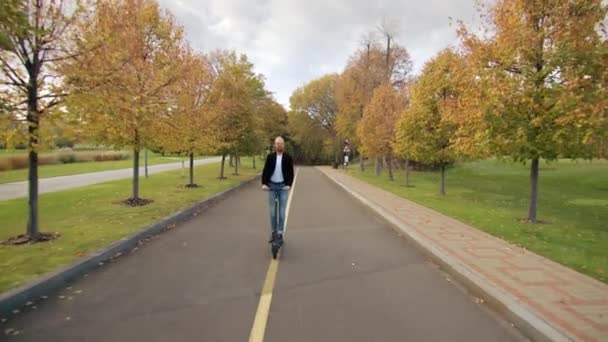 Hombre Despreocupado Jeans Camiseta Blanca Chaqueta Negra Montando Solo Camino — Vídeo de stock