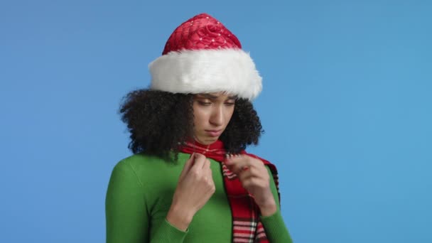 令人失望的黑发女人 穿着绿色的高领毛衣 戴着红色的格子围巾 摸着她的卷发 叹了口气 吐出几乎要哭出来的圣诞帽 高质量的4K镜头 — 图库视频影像