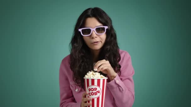彼女の手にポップコーンのブルネットと3Dメガネが映画を見ています 彼女はポップコーンを食べ 注意深く映画に焦点を当てています 高品質の4K映像 — ストック動画
