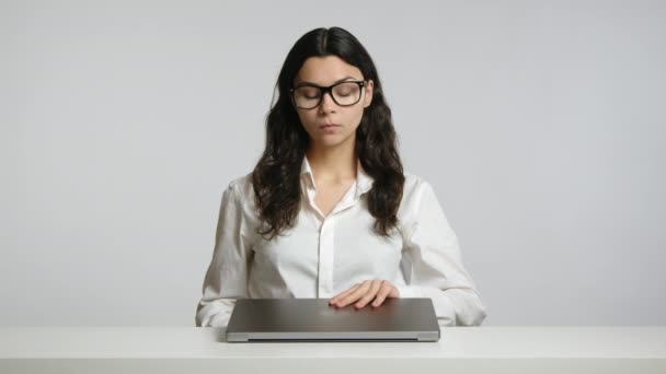 一个戴着眼镜的严厉的年轻女人打开她的笔记本电脑开始工作 她在一间无菌的白色房间里 高质量的4K镜头 — 图库视频影像