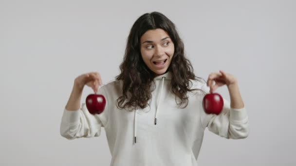 Ένα Όμορφο Κορίτσι Δείχνει Κόκκινα Μήλα Φοράει Λευκή Κουκούλα Λευκό — Αρχείο Βίντεο