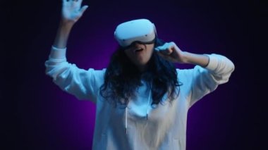 VR gözlüklü genç bir kız sanal bir mikrofonda şarkı söylüyor. O çok mutlu ve kollarını sallarken dans ediyor. Yüksek kalite 4k görüntü