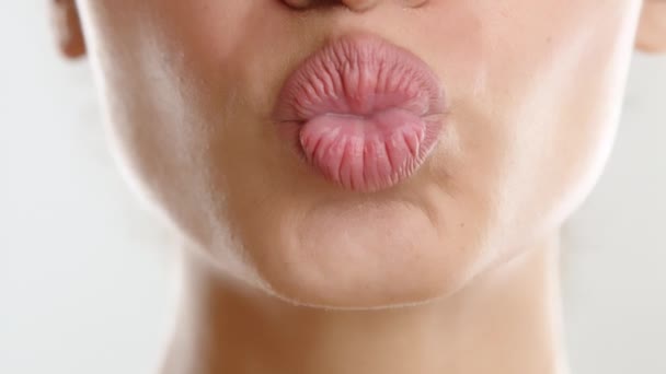 女性の日焼けした皮膚の表面の下部の近くに輝く 女性はキスでヌードリップスティックで完全な唇を折ります 白い歯 高品質の4K映像 — ストック動画