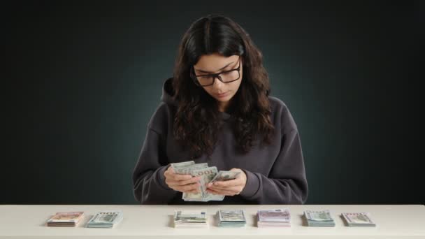白いテーブルの女の子は ドル紙幣を数え テーブルの上に他の人と積み重ねました 彼女はとても幸せで喜んでいる 高品質の4K映像 — ストック動画