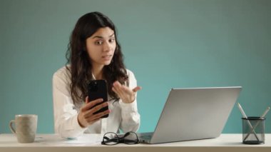 Ofisindeki genç bir kadın, tatsız iş sorunlarıyla ilgili bir video görüşmesi yapıyor. Laptop ekranına bakıyor ve durumu açıklıyor. Yüksek kalite 4k görüntü