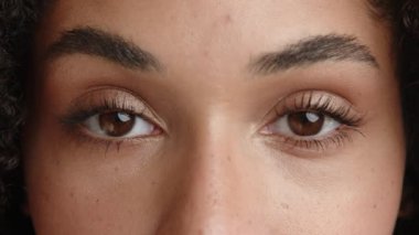 Güzel bir kadın yüzü, egzotik bir görünüş, hatta bronzlaşmış bir ten, kirpiklerinde maskara tabakası olan ela gözler, ciddi bir konsantre görünüm. Yüksek kalite 4k görüntü