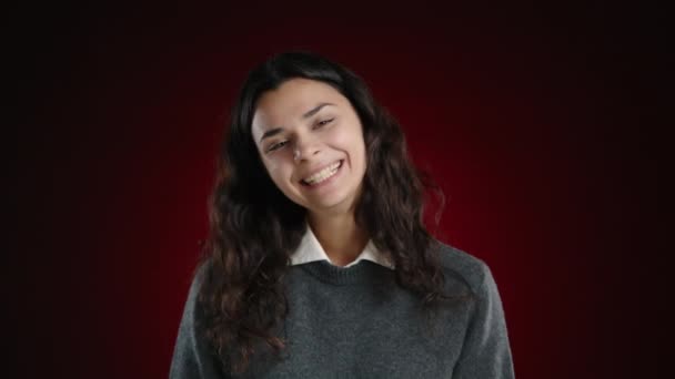Dívka Hystericky Směje Dívá Kamery Neschopná Zastavit Smích Tmavočerveném Pozadí — Stock video