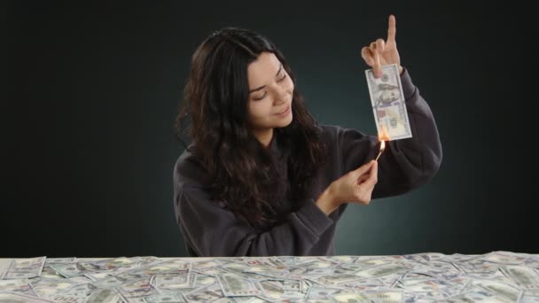 女の子は彼女のお金に囲まれて デモンストレーション的に100ドル札を燃やし 彼女はたくさんのお金を持っていることを示しています 高品質の4K映像 — ストック動画