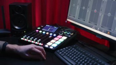 KYIV, UKRAINE, 2 Aralık 2023. Bloglar ve röportajlar için tasarlanmış bir video stüdyosu. Kontrol panelinde bir el ses seviyesini ayarlamak için yukarı doğru bir fader yükseltir.
