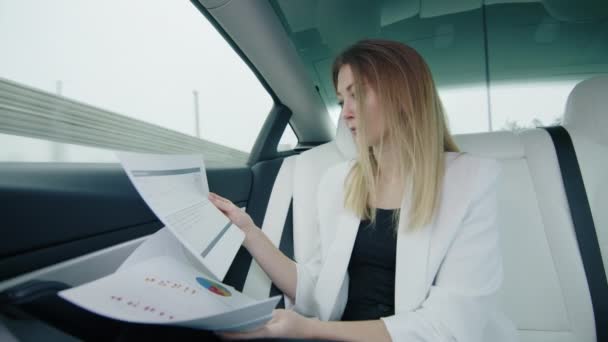 Piękna Dziewczyna Tylnym Siedzeniu Samochodu Pracuje Dokumentami Wykresami Wyglądającymi Skupioną — Wideo stockowe