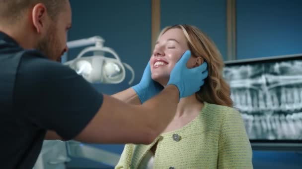 歯の整列をチェックするラテックス手袋の歯科の専門家と 完全に装備されたオフィスで陽気で魅力的な女性の一緒にフィットする方法 高品質の4K映像 — ストック動画